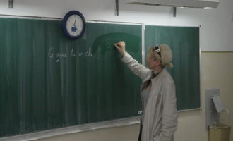 Iemand schrijft een voorbeeldzin op een schoolbord
